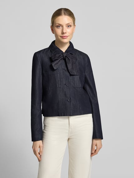 Frauenmodel trägt Blazer mit Schluppe und Brusttaschen von Christian Berg Woman Selection, dunkelblauer Baumwoll-Mix, Regular Fit, Kentkragen, Knopfleiste, helle Hose, Ganzkörperansicht von vorne.