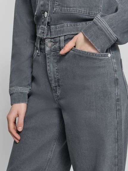 Frauenmodel trägt Relaxed Fit Jeans aus Baumwoll-Mix Modell 'Cellma Edge' von Someday, grauer Baumwoll-Elasthan-Mix, Eingriffstaschen, Knopf-Reißverschluss, Nahaufnahme Oberschenkel.