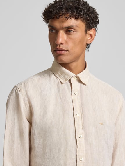 Männermodel trägt Slim Fit Leinenhemd mit Haifischkragen von Fynch-Hatton, Reines Leinen, Label-Stitching, sandfarben, Nahaufnahme Oberkörper.
