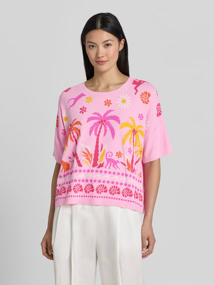 Modelka nosi Strickshirt aus Viskose-Mix im Allover-Look od Milano Italy, mieszanka wiskozy, krój loose fit, wzór na całej powierzchni, okrągły dekolt, długość tyłu w rozmiarze S: 50 cm, przód, ujęcie całej sylwetki.