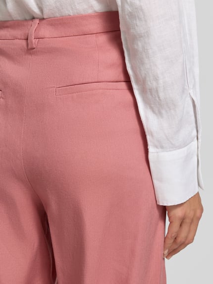 Frauenmodel trägt Stoffhose mit französischen Eingrifftaschen von Jake*s Collection in Rosa, strukturierte Oberfläche, Detailaufnahme Rückansicht, Wide-Leg-Fit, Knopf- und Reißverschluss, Gesäßleistentaschen, Bundweite 40 cm, Innenbeinlänge 106 cm bei Größe 38.