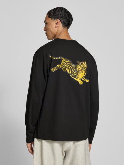 Männermodel trägt Longsleeve aus reiner Baumwolle von Kenzo in Schwarz mit gelbem Label-Print, Regular Fit, Ganzkörperansicht Rückansicht.