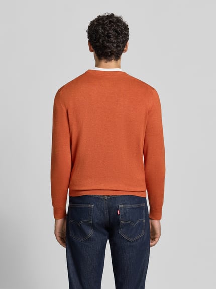 Männermodel trägt Strickpullover mit geripptem Rundhalsausschnitt von MCNEAL in Orange, taillierte Passform, Rückenansicht, Ganzkörperansicht Rückansicht.