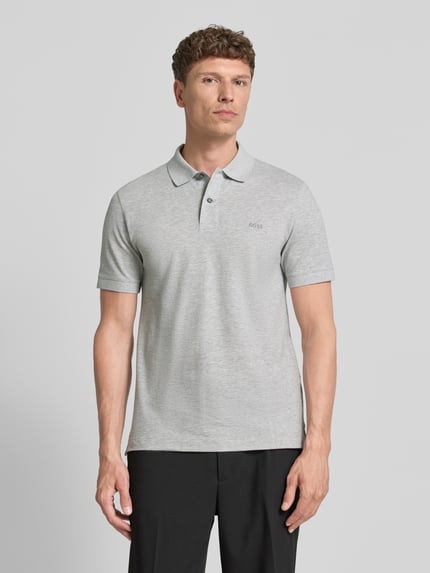 Männermodel trägt Regular Fit Poloshirt aus reiner Baumwolle Modell 'PALLAS' von BOSS in Hellgrau mit Polokragen und kurzer Knopfleiste, Ganzkörperansicht von vorne.