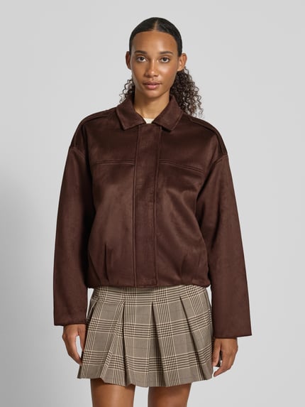 Frauenmodel trägt Regular Fit Blouson in Leder-Optik Modell 'AMBER' von ONLY, braun, glatte Textur, Damen Bomberjacke, Ganzkörperansicht von vorne.