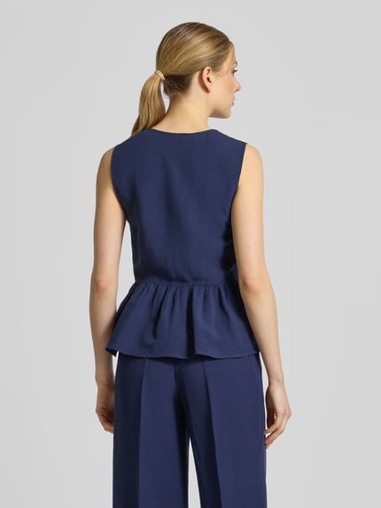 Vrouwenmodel draagt bodywarmer met V-hals en peplum model 'ELMO' van EMME, mix van viscose en linnen, regular fit, ruglengte maat 36: 57 cm, schouderbreedte 33 cm, borstwijdte 41 cm, kleur donkerblauw, gladde stof, geheel lichaamsaanzicht achterzijde
