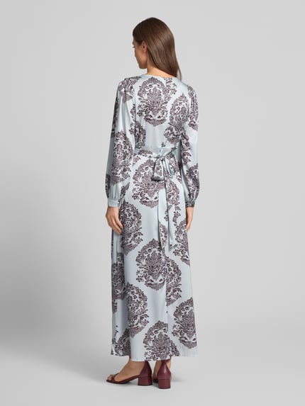Frauenmodel trägt Maxikleid mit V-Ausschnitt Modell 'Bretti' von Neo Noir, Satin mit tailliertem Schnitt, Ganzkörperansicht Rückansicht.