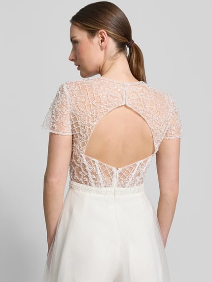 Frauenmodel trägt Jumpsuit mit Perlen und rückseitigem Cut-Out von Unique, semitransparent, Regular-Fit, Rückenansicht, Detailaufnahme. Rückenlänge 40 cm, Brustweite 38 cm, Ärmellänge 17 cm, Gesamtlänge 162 cm, Innenbeinlänge 86 cm, Hakenverschluss.
