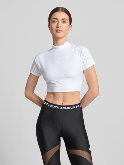 Vrouwenmodel draagt Cropped T-Shirt met Logo en Stehkragen van Under Armour in wit, met materiaalmix met stretch, korte lengte, logoprint, ruglengte bij maat S 30 cm, Ganzkörperansicht van voren.