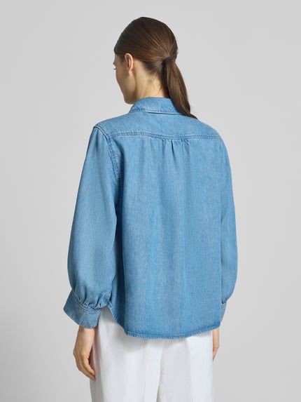 Vrouwenmodel draagt Regular Fit overhemdblouse uit puur lyocell in denimlook van Lanius, langmouw, overhemdkraag, ruglengte 64 cm, mouwlengte 52 cm, lichte blauwe kleur, textuur als denim. Ganzkörperansicht Rückansicht.
