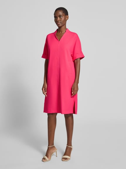 Frauenmodel trägt Knielanges Kleid mit Eingrifftaschen von Milano Italy in Pink, gerader Schnitt, V-Ausschnitt, Halbarm, Material-Mix, Ganzkörperansicht von vorne.