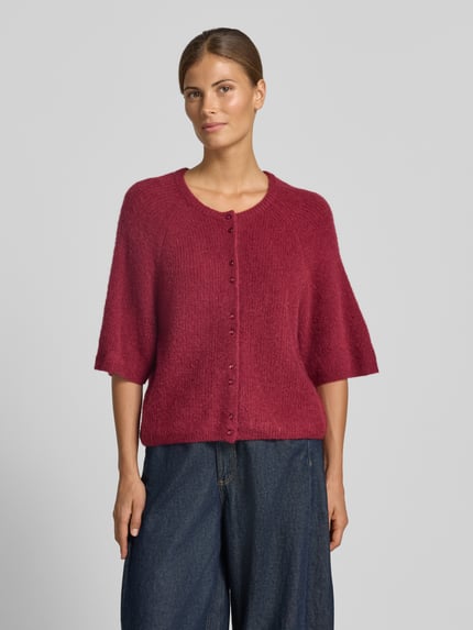 Frauenmodel trägt Strickweste mit 1/2-Arm Modell 'Bondie Hope' von MSCH Copenhagen, rubinrot, Woll-Mix, Regular Fit, Rundhalsausschnitt, Knopfleiste, Ganzkörperansicht von vorne.