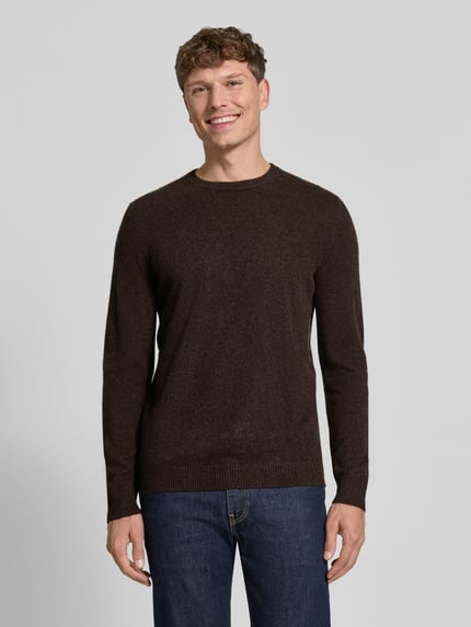 Männermodel trägt Kaschmirpullover mit gerippten Abschlüssen von Christian Berg Men in Dunkelbraun, feine Textur, Ganzkörperansicht von vorne. Reines Kaschmir, gerader Schnitt, Rundhalsausschnitt, Rückenlänge und Ärmellänge bei Größe M je 72 cm.