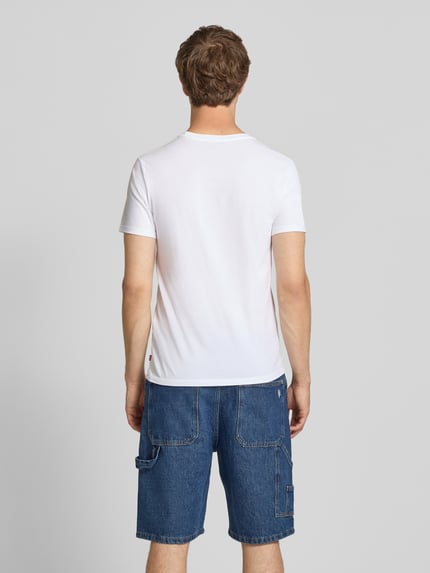 Mężczyzna model nosi biały męski t-shirt krój slim fit z zestawu 2 szt. Slim Fit T-Shirt aus reiner Baumwolle im 2er-Pack Modell '2PK CREWNECK GRAPHIC' von Levi's®, prosta struktura, niebieskie szorty jeansowe, Ganzkörperansicht Rückansicht.