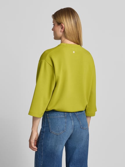 Frauenmodel trägt Sweatshirt mit Tunnelzug Modell 'Tahani' von JOOP!, Damen-Sweatshirt im Regular Fit aus grünem Material-Mix, Ganzkörperansicht Rückansicht