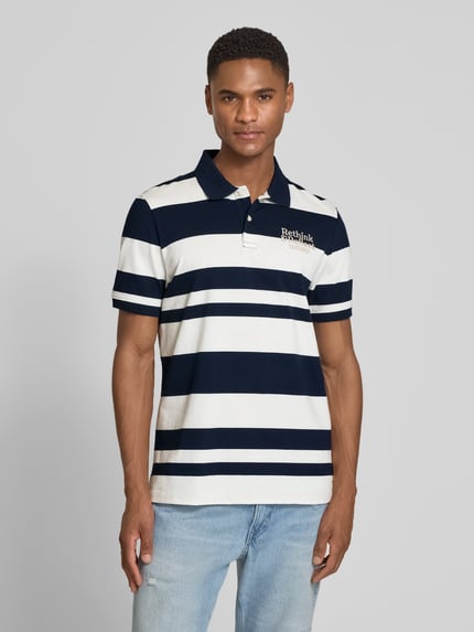 Männermodel trägt Regular Fit Poloshirt aus reiner Baumwolle von s.Oliver RED LABEL, gestreift in Dunkelblau und Weiß, Piqué-Struktur, Ganzkörperansicht von vorne.