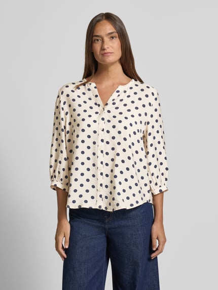 Frauenmodel trägt Regular Fit Bluse aus Viskose-Mix Modell 'Alma' von FREE/QUENT mit V-Ausschnitt und 3/4-Arm, beige mit dunkelblauen Punkten, Ganzkörperansicht von vorne.