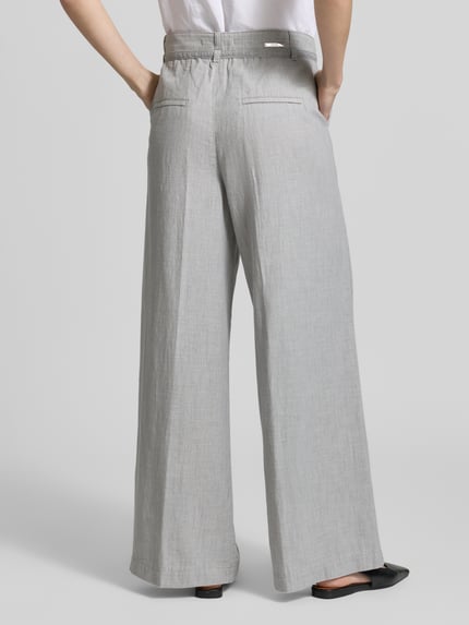 Männermodel trägt spodnie materiałowe Wide Fit Stoffhose mit kanty Modell 'Livia' z bawełna Angels, wpuszczane kieszenie, z tyłu kieszenie z tyłu, zapięcie na guzik i zamek błyskawiczny, szerokość w rozmiarze 36/32: 41 cm, długość wewnętrzna nogawki: 88 cm, jasnoszary kolor, gładka tekstura, Ganzkörperansicht Rückansicht