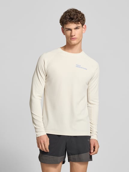 Męski model nosi Longsleeve mit Label-Print Modell 'SORONA' od HALO, krój regular fit, okrągły dekolt, kolor jasny, długość tyłu w rozmiarze M: 66 cm, przód, zdjęcie całej sylwetki