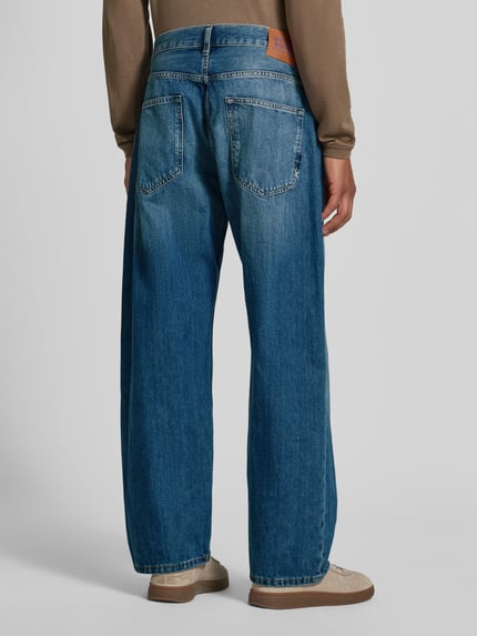 Męski model nosi jeansy Loose Fit Modell 'THE PITCH' od Scotch & Soda, bawełna, efekt znoszenia, wpuszczane kieszenie, szerokość w rozmiarze 32/32: 44 cm, długość wewnętrzna nogawki 74 cm, widok całej sylwetki z tyłu.