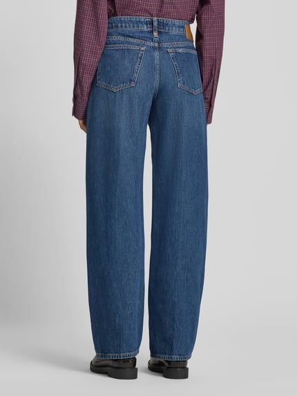 Frauenmodel trägt Relaxed Fit Jeans aus reiner Baumwolle von DRYKORN, 5-Pocket-Design, mittlere blaue Farbe, Ganzkörperansicht Rückansicht.