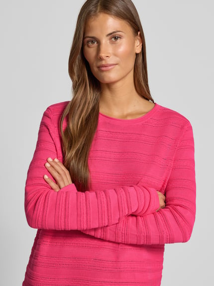 Frauenmodel trägt Regular Fit Pullover aus reiner Baumwolle in Strick-Optik von Christian Berg Woman in kräftigem Pink, semitransparent, Nahaufnahme Oberkörper.