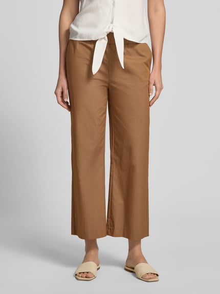 Vrouwenmodel draagt dames broek met katoenmix en stretch van monari, verkorte pasvorm, elastische band, model 'Sarah', binnenbeenlengte 65 cm, bandwijdte maat 36, voorkant volledig in beeld, detailopname onderlichaam.