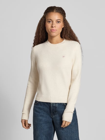 Kobieta modelka ma na sobie Slim Fit sweter z dzianiny z elastyczną mieszanką materiałów 'Slim Fit Strickpullover aus elastischem Material-Mix' od REVIEW, kremowy kolor, wyhaftowany motyw, prążkowane wykończenia, długość tyłu w rozmiarze S: 51 cm, długość rękawów w rozmiarze S: 61 cm, widok na cały górny korpus z przodu