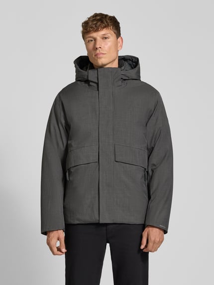 Männermodel trägt Jacke mit Kapuze und Pattentaschen Modell 'LAMOON' von JACK & JONES, Regular Fit, verdeckter Reißverschluss, Ganzkörperansicht von vorne.