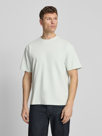 Mannelijk model draagt Oversized T-Shirt met ronde halslijn van Lindbergh, puur katoen, oversized fit, labeldetail, ruglengte maat M 70 cm, volledige lichaamsaanzicht voorkant