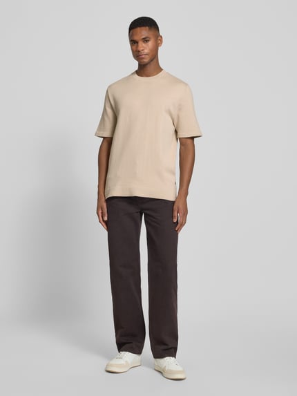 Männermodel trägt T-Shirt mit Label-Detail Modell 'MILANO' von Jack & Jones Premium, Baumwoll-Mix, gerade Form, Ganzkörperansicht von vorne.