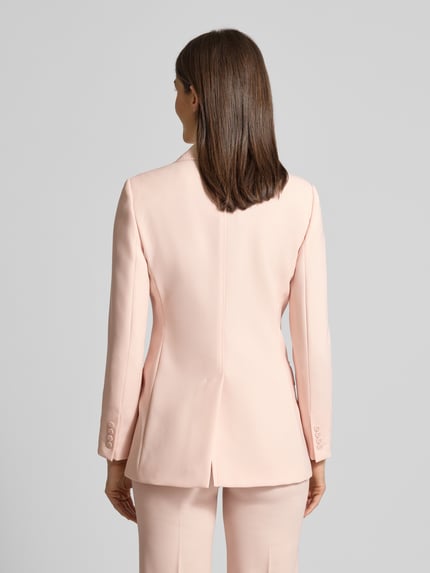 Frauenmodel trägt Regular Fit Longblazer aus reiner Schurwolle von Max Mara Studio in zartem Rosa, doppelte Knopfleiste, Pattentaschen, Ganzkörperansicht Rückansicht.
