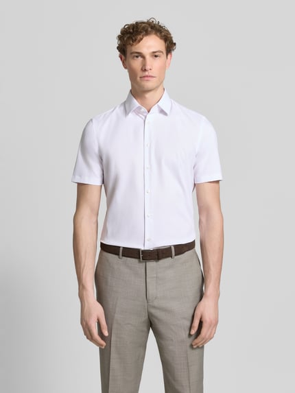 Männermodel draagt Slim Fit Business-Hemd mit kentkraag van Jake*s, elastische materiaalmix, zakelijk, knoopsluiting, met korte mouwen, ruglengte maat 39/40: 80 cm, schouderbreedte maat 39/40: 45 cm, mouwlengte maat 39/40: 25 cm, lichtroze, gladde stof, effen, Ganzkörperansicht van voren.