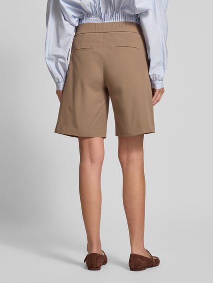Vrouwenmodel draagt Schlupfbermuda Techno Cotton Superstretch van Raffaello Rossi, regular fit, elastische band, achterzak, model 'ISKA', beige kleur, gladde structuur, context: dames Schlupfbermuda met een bandwijdte van 39 cm en binnenbeenlengte van 24 cm in maat 36, volledige lichaamsaanzicht achterkant.
