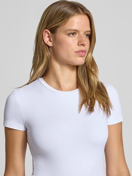 Vrouwenmodel draagt wit slim fit t-shirt met ronde hals model 'LULA' van PIECES, dames t-shirt, close-up bovenlichaam.