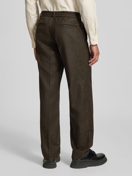 Männermodel trägt Straight Fit Anzughose aus Woll-Mix von Forét in Dunkelbraun mit Bundfalten, Gesäßtaschen, Ganzkörperansicht Rückansicht. Kontext: Herren Anzughose von Forét, Woll-Mix, Knopf- und Reißverschluss, Eingriff- und Gesäßtaschen, Innenbeinlänge bei Größe M: 82 cm, Bundweite bei Größe M: 37 cm.