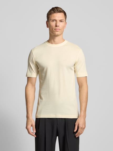 Männermodel trägt T-Shirt mit geripptem Rundhalsausschnitt von Drykorn in Beige, reine Baumwolle, Regular Fit, Ganzkörperansicht von vorne.