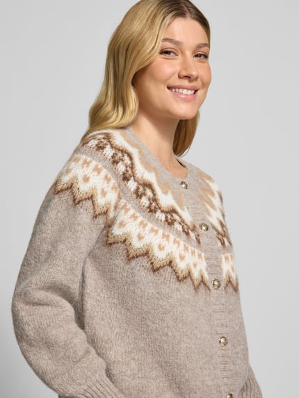 Frauenmodel trägt Strickjacke mit Norweger-Muster und Rundhalsausschnitt von Christian Berg Woman Selection, neutrale Töne, Material-Mix mit Woll-Anteil, Knopfleiste, Regular Fit, Nahaufnahme Oberkörper.