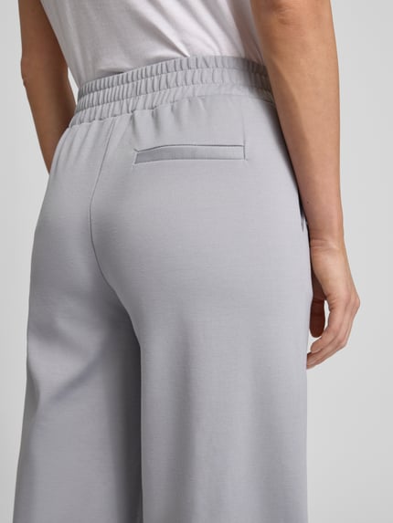 Frauenmodel trägt Wide Fit Stoffhose mit Viskose-Anteil Modell 'Kate' von ICHI, hellgrauer Elastischer-Material-Mix, Detailaufnahme Rückansicht.