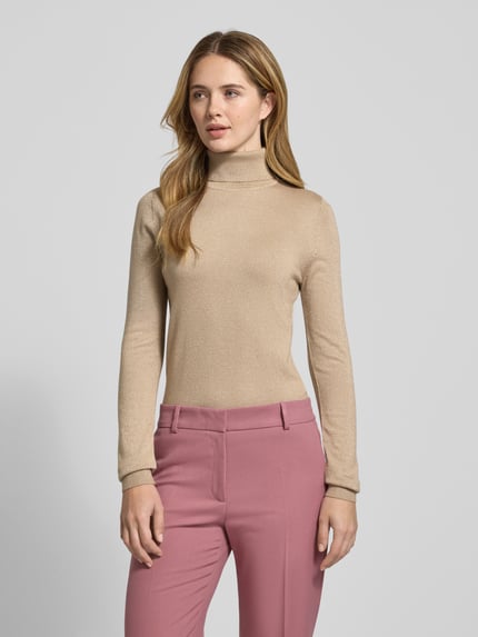 Frauenmodel trägt Slim Fit Rollkragenpullover aus Viskose-Mix Modell 'HAPPYSHINE' von Vero Moda, unifarben, schimmernd, Strick, Ganzkörperansicht von vorne.