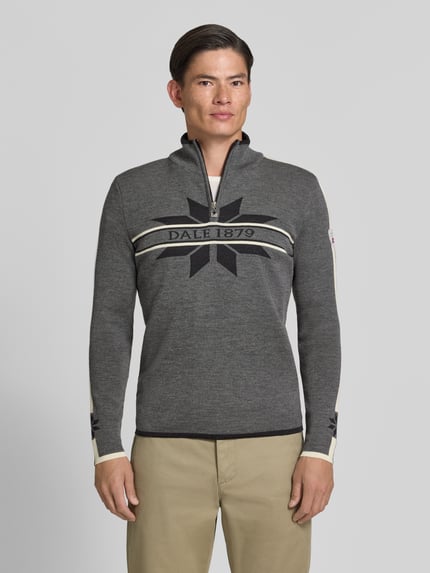 Männermodel trägt Wollpullover mit Label-Print Modell 'Nale' von Dale of Norway, reine Wolle, gerader Schnitt, Ganzkörperansicht von vorne.