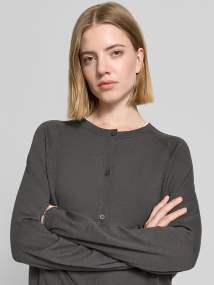 Frauenmodel trägt Relaxed Fit Strickjacke aus Baumwoll-Leinen-Mix von Marc O'Polo, Optik: Unifarben, Rundhals, Langarm, einreihige Knopfleiste, Nahaufnahme Oberkörper.