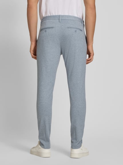 Mannelijk model draagt Slim Fit Chino uit viscosemix model 'MARK' van Only & Sons, effen mêlee look, achterzakken, riemlussen, knoop- en ritssluiting, detailopname hele lichaam achterkant.