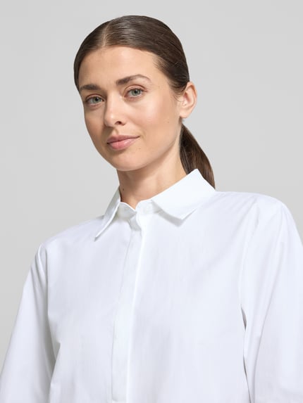 Frauenmodel trägt Regular Fit Hemdbluse im Halbarm-Design Modell 'Netti' von Soyaconcept in Weiß, Material-Mix mit Baumwoll-Anteil, Nahaufnahme Oberkörper.