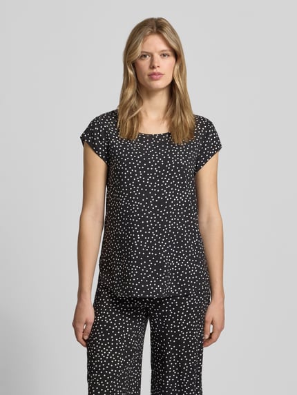 Frauenmodel trägt Regular Fit Blusenshirt aus reiner Viskose Modell 'NOVA' von Only mit Allover-Muster, Rundhals, kurzarm, Ganzkörperansicht von vorne.