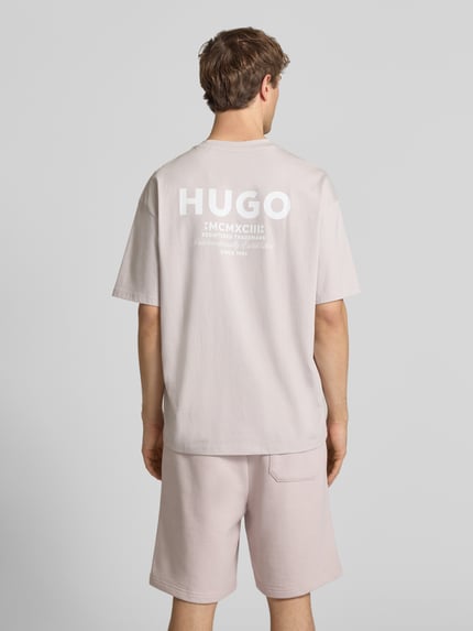 Männermodel trägt Loose Fit T-Shirt aus reiner Baumwolle Modell 'Nalono' von HUGO in Optik: Unifarben mit Label-Detail, Ganzkörperansicht Rückansicht.