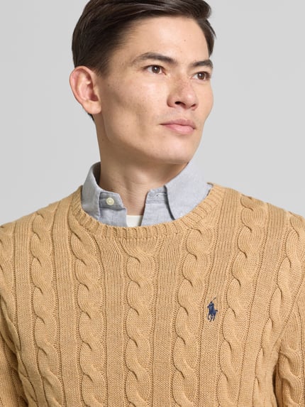 Männermodel trägt Strickpullover mit Label-Stitching von Polo Ralph Lauren in Beige, reine Baumwolle, Regular-Fit, Rundhalsausschnitt, Nahaufnahme Oberkörper.
