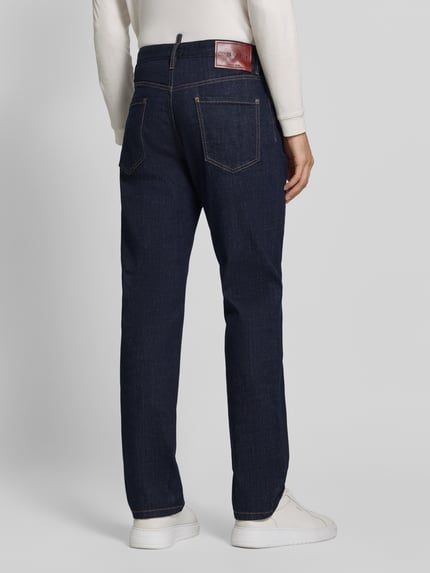 Männermodel trägt Regular Fit Straight Fit Jeans mit Label-Detail von Dsquared2, dunkelblaue Denim-Struktur, 5-Pocket-Design, Ganzkörperansicht Rückansicht.