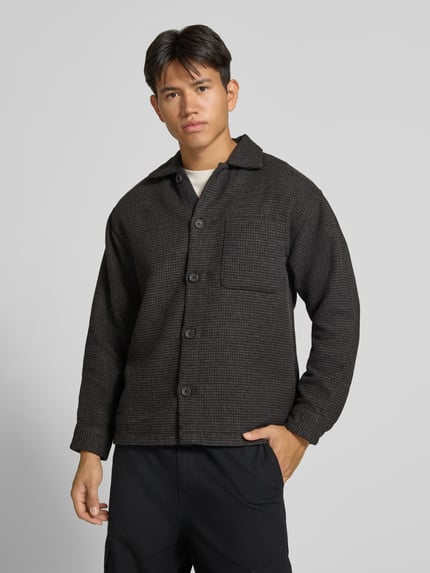 Männermodel trägt Regular Fit Hemdjacke mit Brusttasche Modell 'SOHO OLLIE' von JACK & JONES in dunklem Grau, Ganzkörperansicht von vorne. Rückenlänge 71 cm, Schulterbreite 41 cm, Ärmellänge 65 cm.