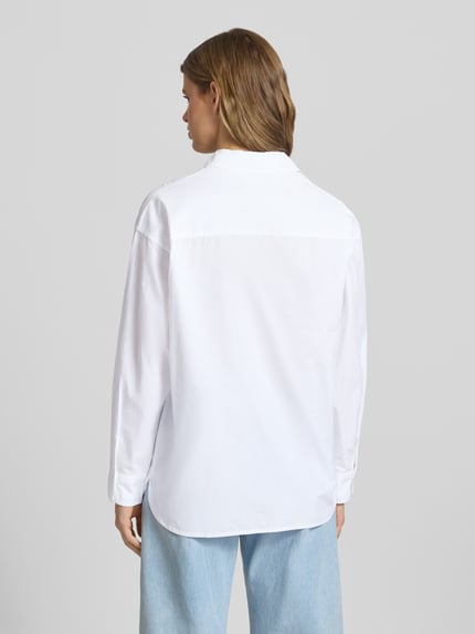 Kobiece modelka nosi Basic Hemd aus Baumwolle mit Hemdblusenkragen od Review, biała bawełna, krój regular fit, sportowe mankiety, zaokrąglony dół, widoczna listwa guzikowa, długość tyłu 73 cm, długość rękawów 55 cm, widok całej sylwetki z tyłu